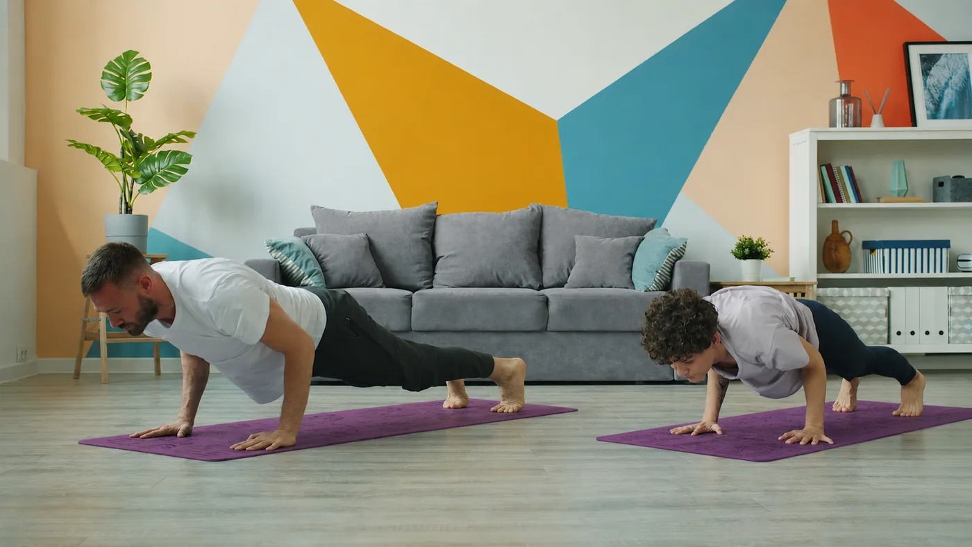 An adult and child holding a plank together at home